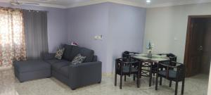 a living room with a couch and a table with chairs at Purple Springs Elmina #3 in Esamang +9 photos