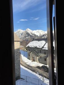 a view of a snow covered mountain from a window at Apartamento la Abadía en Tramacastilla in Tramacastilla de Tena