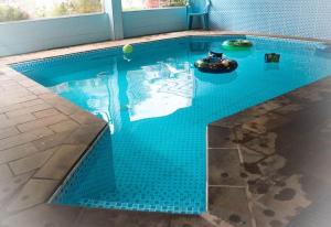 a large swimming pool with a blue tiled floor at Hotel Estância in Poços de Caldas