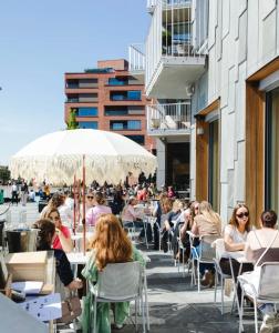 a group of people sitting at tables on a patio at Sunny apartment close to the sea in Oslo