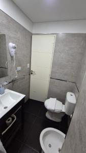 a bathroom with a white toilet and a sink at Departamento en el Centro in Puerto Madryn +19 photos