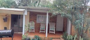 two chairs sitting on a porch of a house at LUZ BELLA 2 in Oberá
