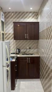 una cucina con mobili in legno e un frigorifero di التميز للشقق فرع ثاني المخدومة a Al Majmaah Altre 5 foto
