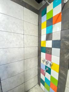 y baño con ducha y azulejos de colores. en Container House, en San Rafael 23 fotos más