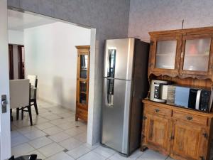 a kitchen with a stainless steel refrigerator and wooden cabinets at Casa Maciel in São Thomé das Letras