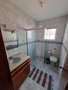 a bathroom with a shower and a sink and a toilet at Casa Maciel in São Thomé das Letras