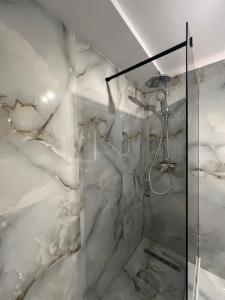 a bathroom with a shower with white marble walls at Lagoon Studio 705 in Bucharest +42 photos