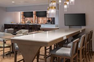 Un bar con una mesa grande y sillas. en Fairfield by Marriott Issaquah, en Issaquah