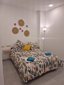 a bedroom with a bed with a comforter on it at Apto Islote in Arrecife