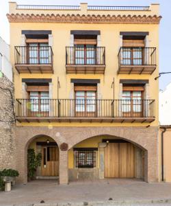 un edificio amarillo con ventanas y balcones en Complejo Rural Turimaestrat, en Sant Mateu