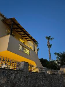 een geel huis met een palmboom op de achtergrond bij Vivi's Apartments Loft in Spetses