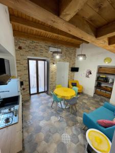 a living room with a yellow table and chairs at Hermès Home in Agrigento