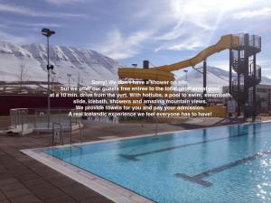 a sign next to a swimming pool with a water slide at Iceland yurt in Akureyri