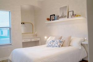 a white bedroom with a bed and a mirror at Luxurious Gated 3BR Oasis No chore Pet friendly in Edinburg