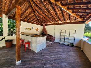 une cuisine ouverte avec des plafonds en bois et un plancher en bois dans l'établissement Casas de Campo, à Cachoeira Paulista