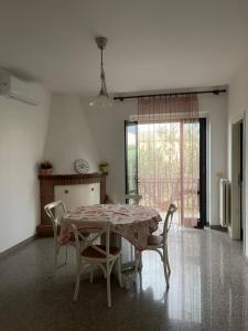 a dining room with a table and chairs and a window at Appartamenti in Villa incanto dei trabocchi Un gioiello esclusivo tra mare e natura in Treglio