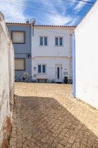 una grande casa bianca con un cortile in mattoni di Casa Clara a Vila do Bispo