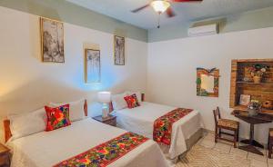 a room with two beds and a table with a desk at Hotel Itzae in Copán Ruinas +16 photos