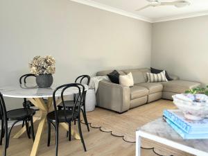a living room with a couch and a table at Little Avalon House in Whale Beach
