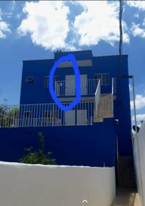 ein blaues Haus mit einem darauf gemalten blauen Kreis in der Unterkunft Hospedaria Coração de Pedra in São Thomé das Letras
