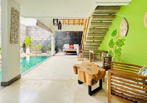 ein Wohnzimmer mit Pool und grünen Wänden in der Unterkunft The Loft Villas Echo in Canggu