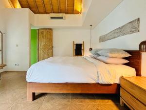 ein Schlafzimmer mit einem Bett mit Kissen darauf in der Unterkunft The Loft Villas Echo in Canggu
