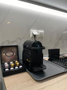 a coffee maker and a box of cupcakes on a counter at Irene Beach Front Luxury Suite in Perea