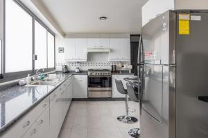 a kitchen with white cabinets and stainless steel appliances at Posh Polanco Stay TVs and Desks in Each Room in Mexico City +61 photos