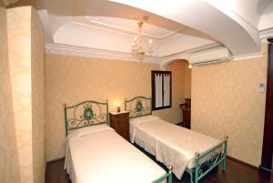 2 Betten in einem Zimmer mit gelber Tapete in der Unterkunft Appartmento Ca' Rio Marin in Venedig