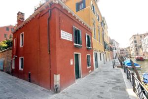 a red building on the side of a canal at Appartmento Ca' Rio Marin in Venice