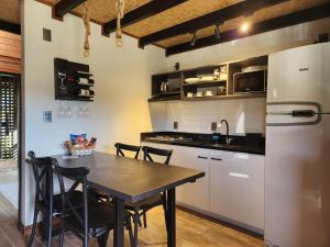 a kitchen with a table and a refrigerator at Pousada Contos e Sonhos in Urubici
