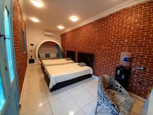a bedroom with two beds and a brick wall at iBiZa Hostel in Beni Suef