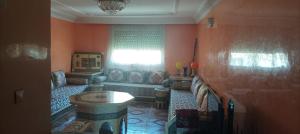 ein Wohnzimmer mit einer Couch und einem Fenster in der Unterkunft Appartement à louer pour famille et couple marié in Mohammedia