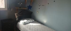 ein Schlafzimmer mit einem Bett mit einem hölzernen Kopfteil in der Unterkunft Appartement à louer pour famille et couple marié in Mohammedia