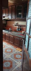 eine Küche mit Holzschränken und Fliesenboden in der Unterkunft Appartement à louer pour famille et couple marié in Mohammedia