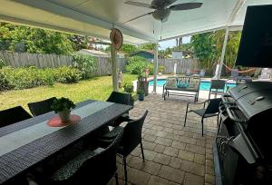 a patio with a table and chairs and a pool at Pool House Resort heated swimming pool private duplex in Cutler Bay
