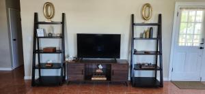 a living room with a flat screen tv on a entertainment center at Experience Cruzan Comfort in Christiansted