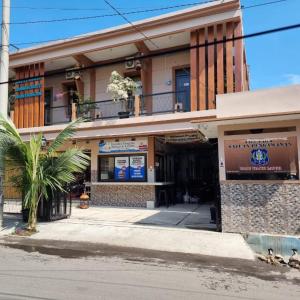 a building with a palm tree in front of it at pondok Syariah Hadikusuma in Rahayu +19 photos