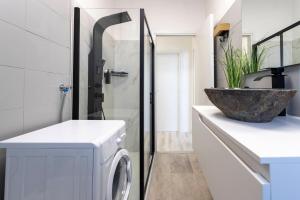a bathroom with a washing machine and a sink at Mountain View Apartment in Novara +18 photos