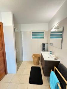 um banheiro com pia e chuveiro em Charmant studio vue mer imprenable, proche plage em Le Gosier