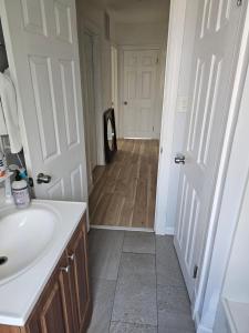 un bagno con lavandino bianco e porta bianca di Small cozy room, shared bathroom a Baltimora