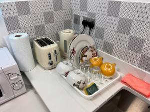 eine Küchentheke mit einem Tablett mit Geschirr und Geräten in der Unterkunft Haven Homes - Central Luton Studio Apartments in Luton + 106 Fotos