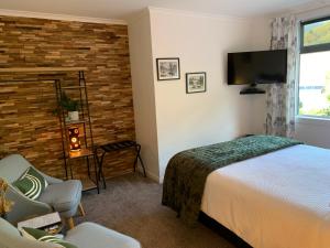 a bedroom with a bed and a flat screen tv at Koru Havenz in Picton