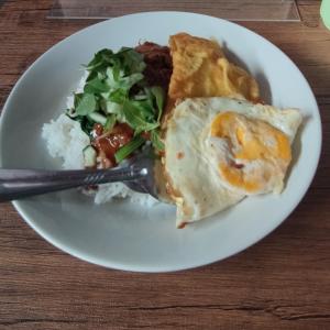 a plate of food with a egg and a salad at pondok Syariah Hadikusuma in Rahayu