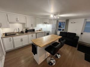 a kitchen with white cabinets and a wooden counter top at La Suite Centre-ville Saint-Georges in Saint-Georges