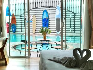 Schlafzimmer mit Pool und Surfbrettern an einer Wand in der Unterkunft A-Te Chumphon Hotel - SHA Plus in Chumphon + 37 Fotos