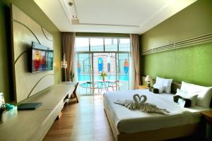 ein Hotelzimmer mit einem Bett mit einem Handtuch darauf in der Unterkunft A-Te Chumphon Hotel - SHA Plus in Chumphon
