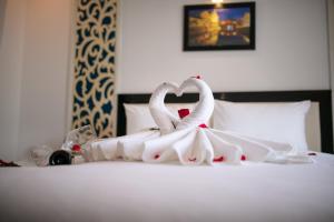 Postel nebo postele na pokoji v ubytování Hoi An Rose Garden Hotel