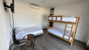 a small room with two bunk beds and a table at El Rincón de Don Javier Casa de Playa in El Platano