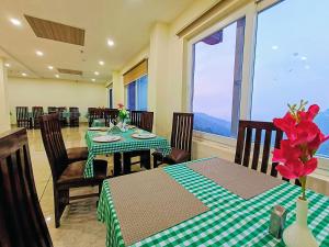 a dining room with two tables and a large window at Hotel Pines And Peeks By Tws Hotels in Dalhousie
